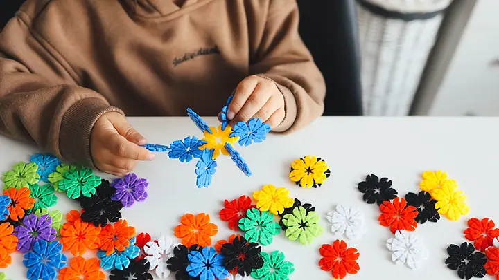 Criança montando peças de encaixe coloridas