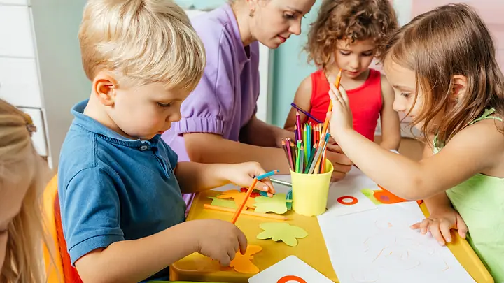 Crianças desenhando com uma professora